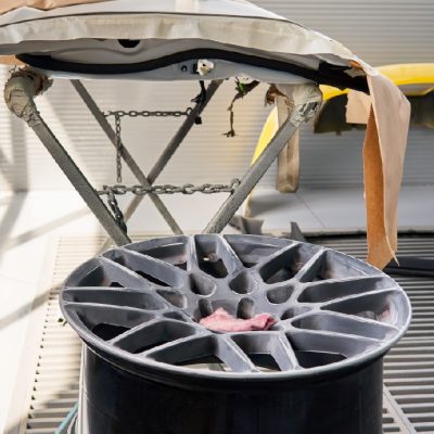 Bumpers hanging in auto service shop after painting and drying in garage